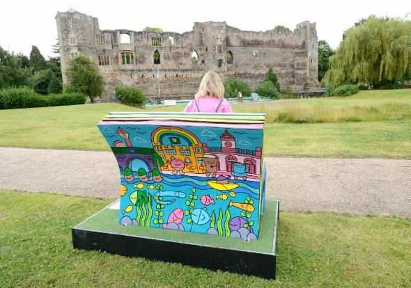 Woman sat on a bench in front of Newark Castle Woman sat on a bench in front of Newark Castle