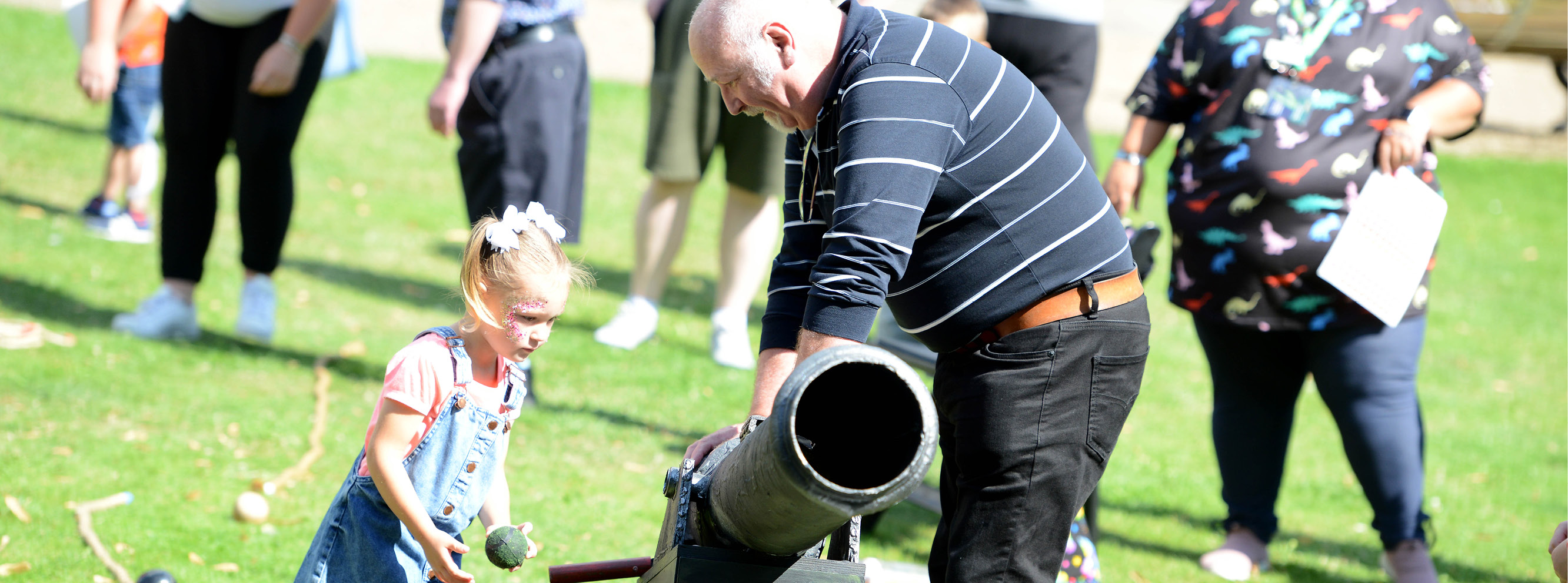 A man and little girl load a fake cannon in Newark Castle grounds for our Family Play Day in 2021