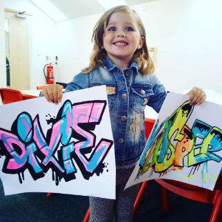 Child holding graffiti artwork Child holding graffiti artwork