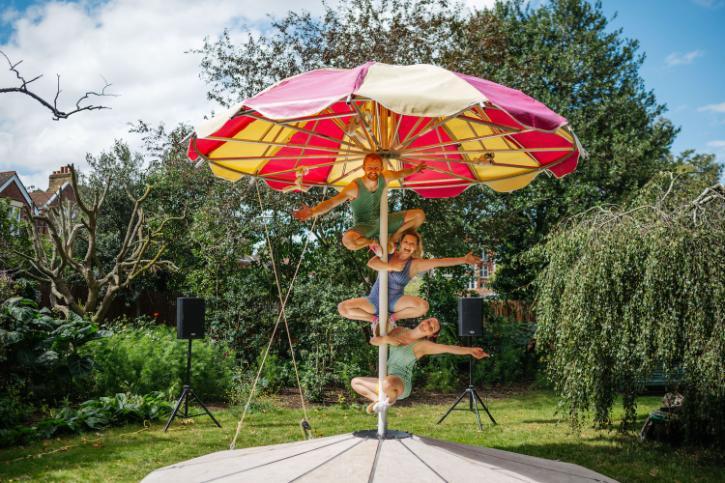 circus act climbing a parasol as part of the performance